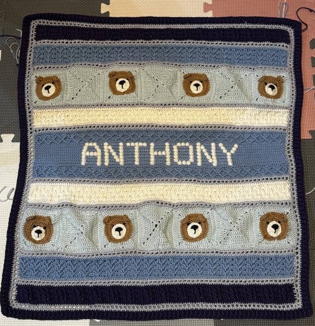 My blue and cream baby blanket with crocheted bear faces